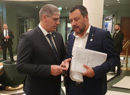 Minister Poklukar in minister Salvini stojita drug ob drugem in se pogovarjata.