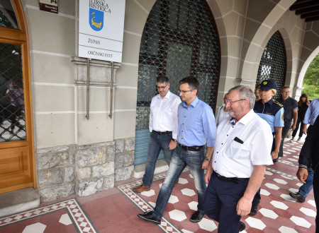 Predsednik vlade Šarec, minister Poklukar in župan Ilirske Bistrice Emil Rojc hodijo ob občinski stavbi