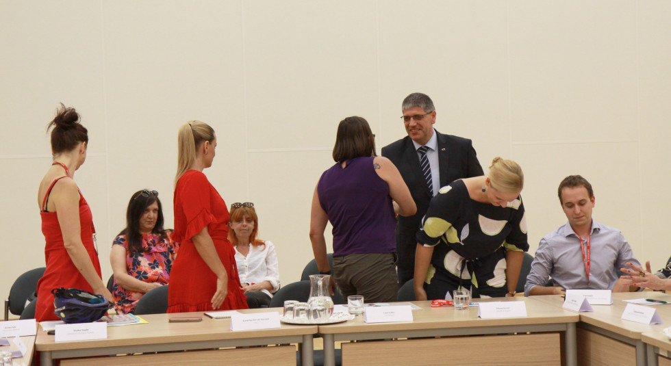 Minister Boštjan Poklukar se v sejni sobi rokuje s predstavniki nevladnih organizacij.