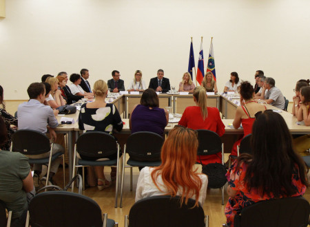 Predstavniki ministrstva in nevladnih organizacij sedijo za mizo.