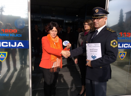 Predsednica združenja Spominčica - Alzheimer Slovenija Štefanija Lukič Zlobec in direktor Policijske uprave Murska Sobota se rokujeta in pokažeta nalepko demenci prijazne točke pred njeno namestitvijo