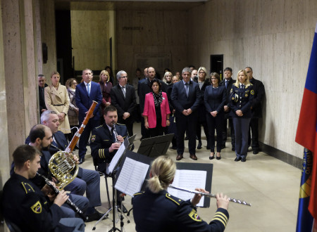 Udeleženci dogodka stojijo in kvintet Policijskega orkestra med igranjem skladbe