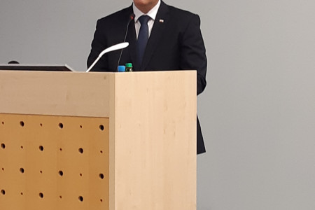 Minister Poklukar stoji za govornico in govori