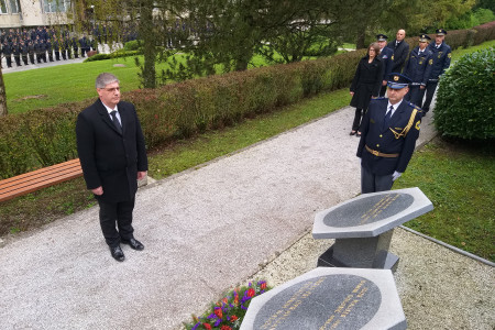 Minister Poklukar se pred spominskim obeležjem v Tacnu pokloni umrlim policistom