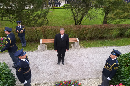 Minister Poklukar se pred spominskim obeležjem v Tacnu pokloni umrlim policistom