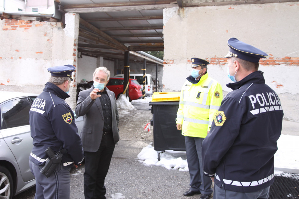 Obisk ministra Aleša Hojsa na Policijski postaji Postojna, minister in policisti stojijo pred stavbo in se pogovarjajo.