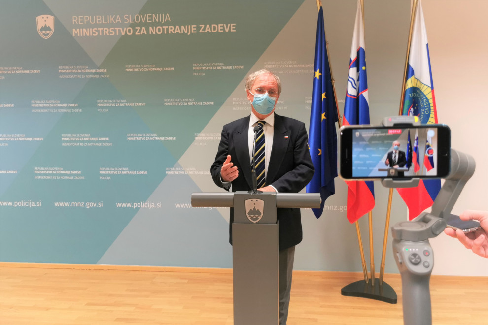 Minister Aleš Hojs stoji za govornico.