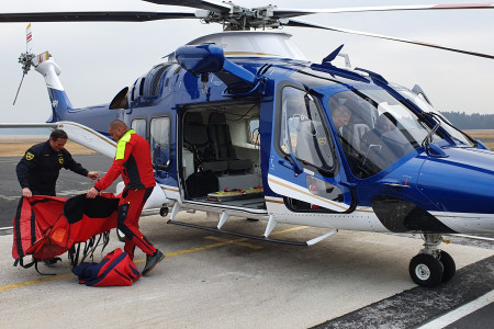 V helikopterju so piloti, pred njim reševalec in policist