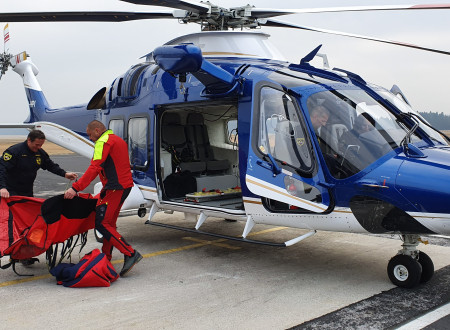 V helikopterju so piloti, pred njim reševalec in policist