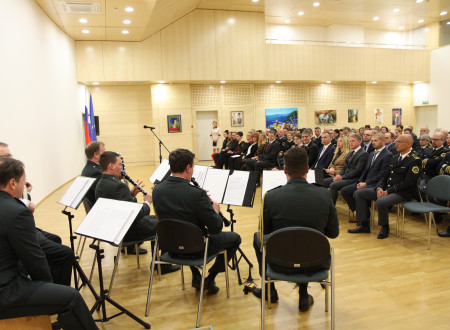 V ospredju policijski orkester, v ozadju občinstvo