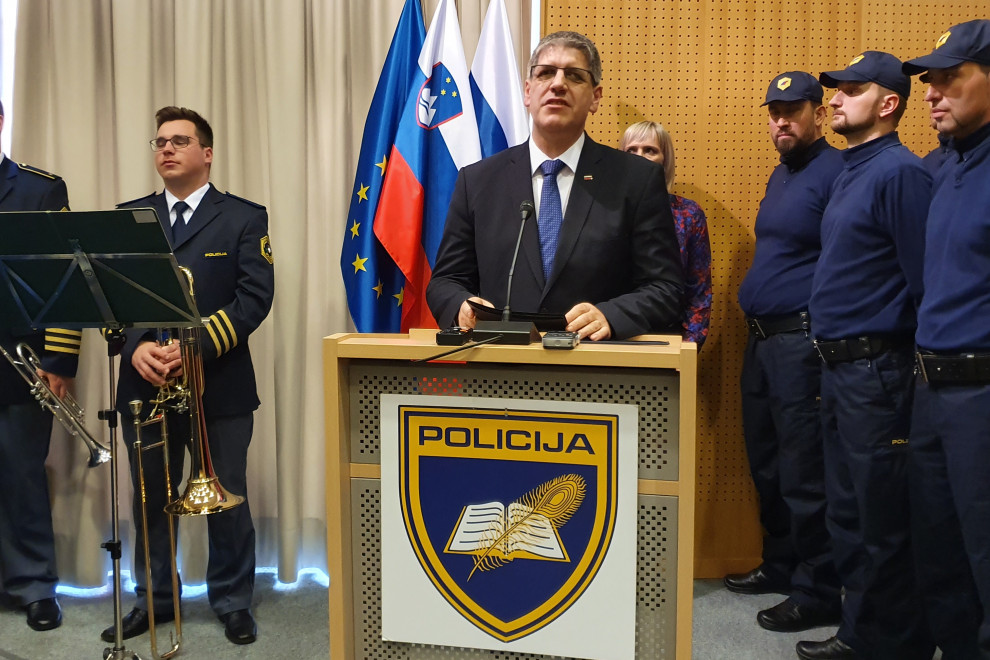 Minister Boštjan Poklukar nagovarja policiste za govornico v dvorani Policijske akademije