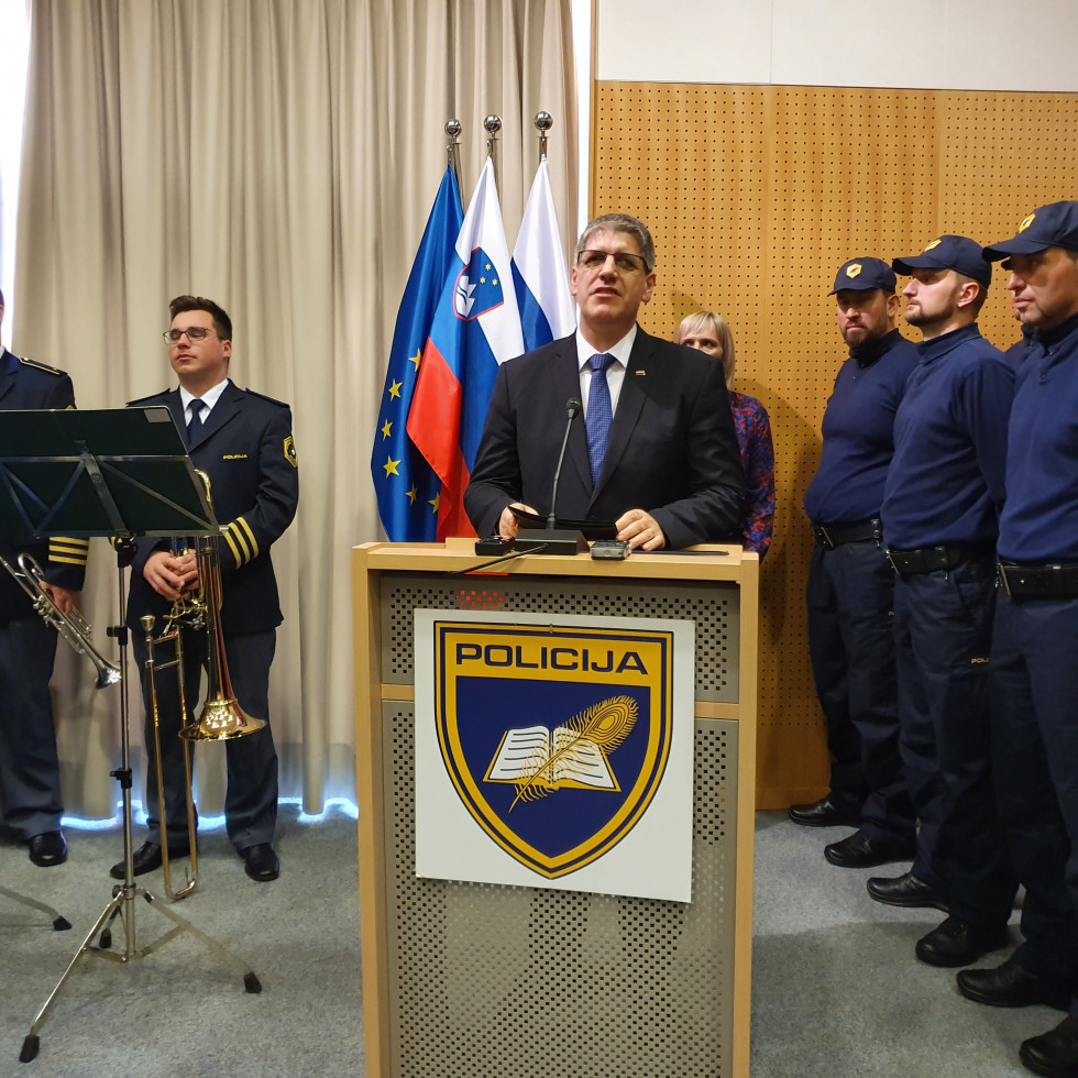 Minister Boštjan Poklukar nagovarja policiste za govornico v dvorani Policijske akademije