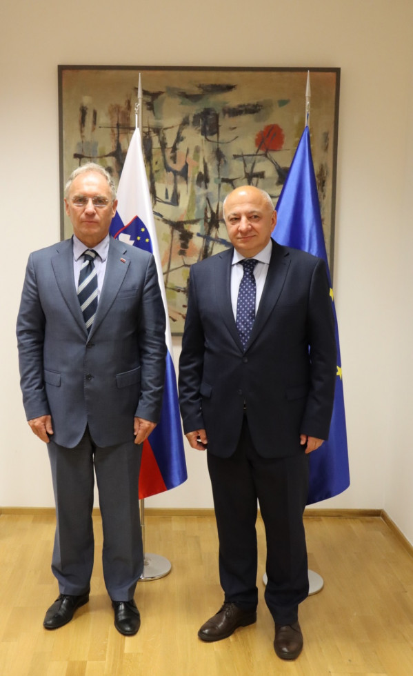 Minister Aleš Hojs in veleposlanik Črne gore Vujica Lazović stojita pred zastavami