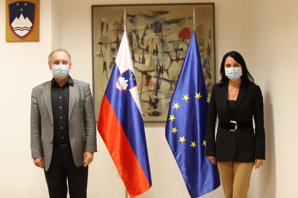 na fotografiji stojita minister Aleš Hojs in izvršna direktorica Evropskega azilnega podpornega urada Nina Gregori ob zastavah 