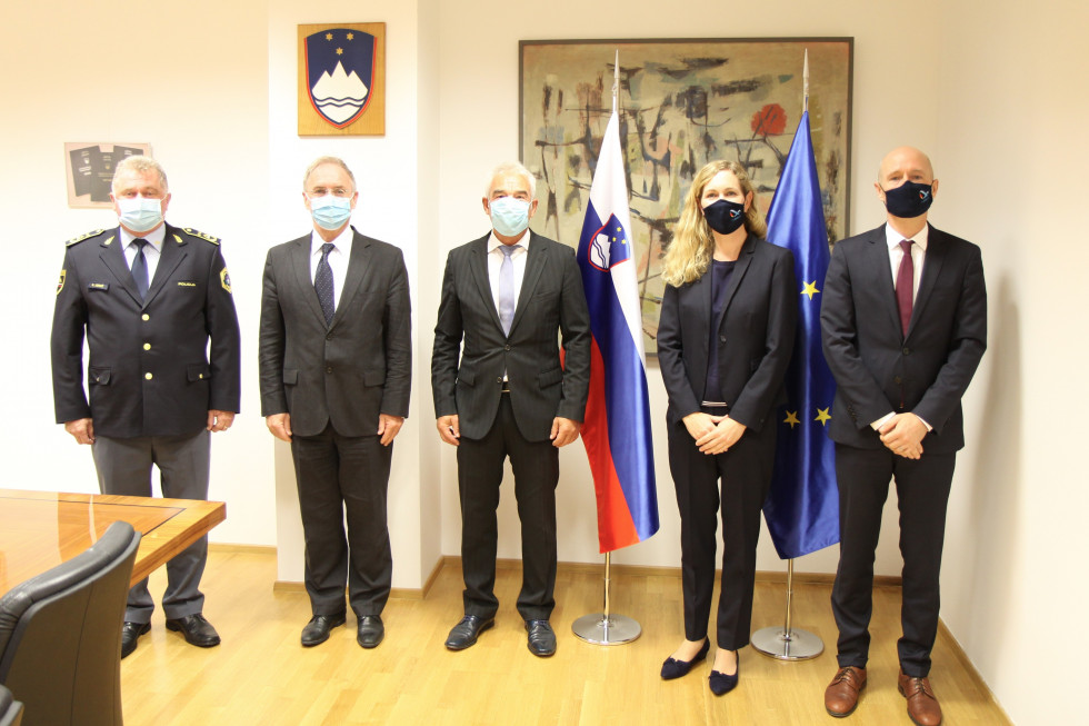 V. d. generalnega direktorja policije Andrej Jurič, minister za notranje zadeve Aleš Hojs, policijski ataše Uwe Dietrich in veleposlanika Nemčije Nathalie Kauther in Adrian Pollmann stojijo pred zastavami v sejni sobi