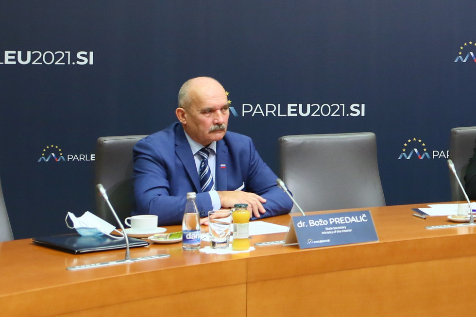 Državni sekretar dr. Božo Predalič sedi za mizo