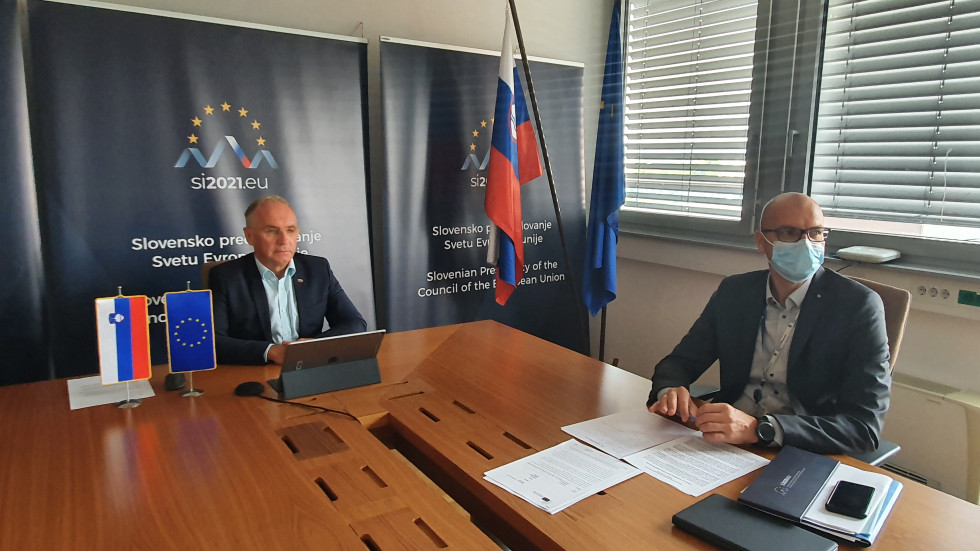Minister Aleš Hojs in pomočnik generalnega direktorja policije Jože Senica sedita za mizo in poslušata razpravo