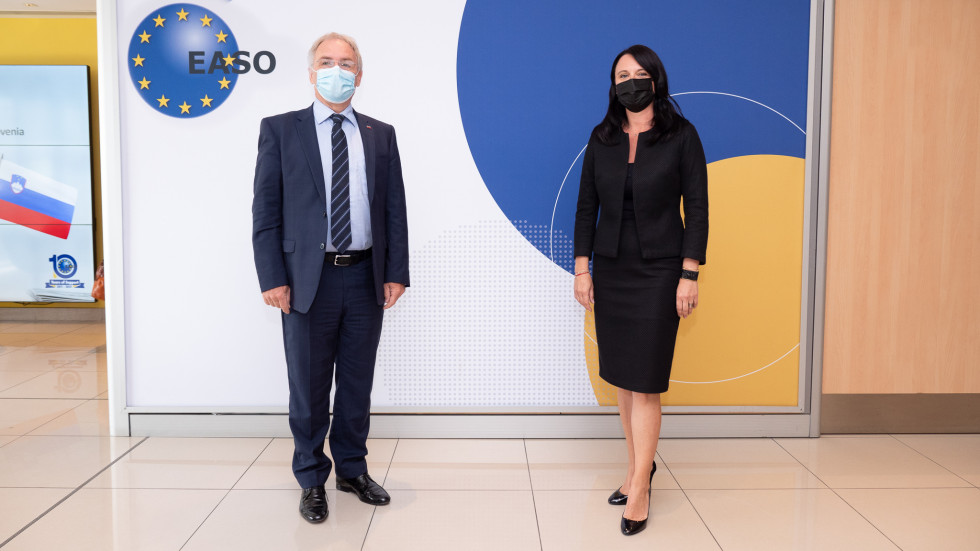 Minister Aleš Hojs in izvršna direktorica EASO Nina Gregori stojita pred ozadjem EASO