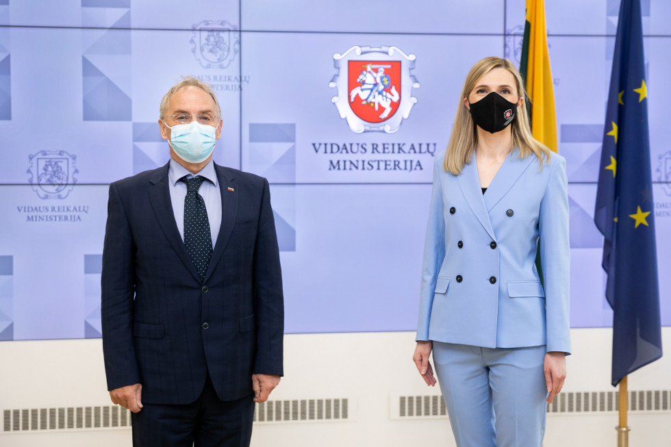 Minister Aleš Hojs in Agne Bilotaite stojita pred zastavami