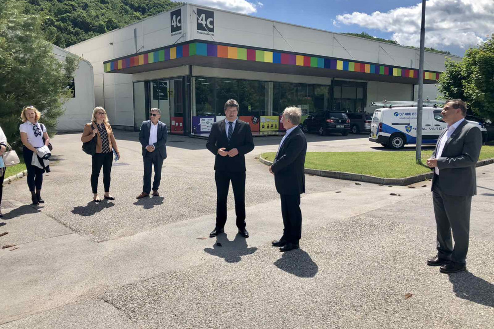Minister Aleš Hojs in župan Občine Brežice Ivan Molan stojita zunaj pred stavbo Občine Brežice in se pogovarjata