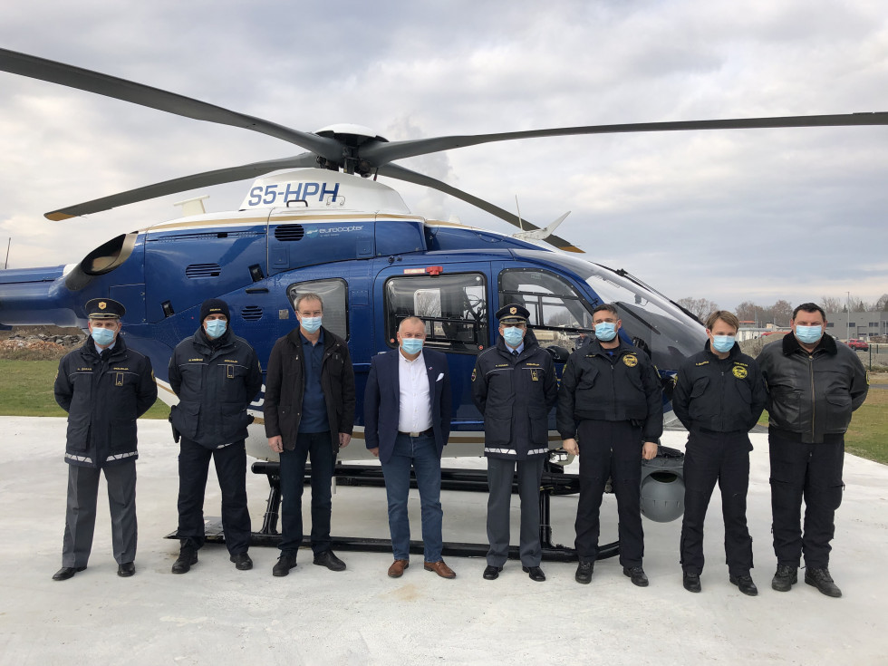 Policisti in državni sekretar Franc Kangler pred policijskim helikopterjem