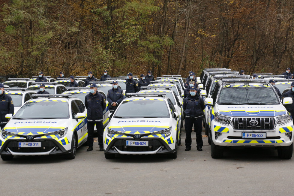 Policija je prevzela 41 specialnih patruljnih vozil na hibridni pogon. Poleg vsakega vozila stoji policist.
