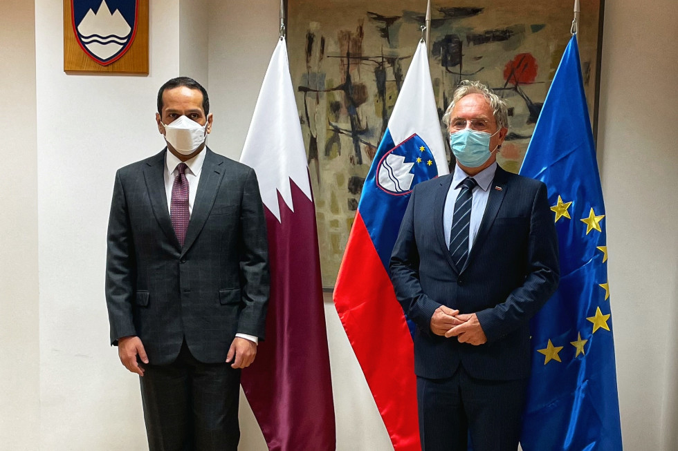 Minister za notranje zadeve Aleš Hojs in podpredsednik vlade in minister za zunanje zadeve Države Katar šejk Mohammed bin Abdulrahman bin Jassim Al-Thani. Stojita pred zastavami.
