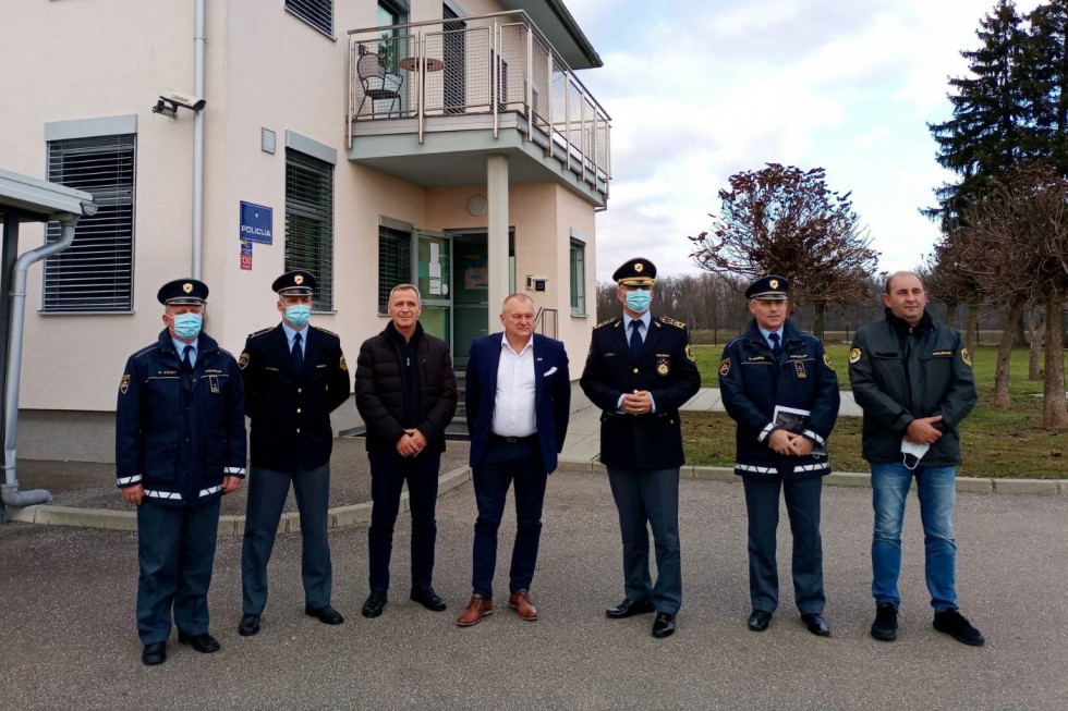 Državni sekretar Franc Kangler in generalni direktor policije dr. Anton Olaj stojita skupaj s policisti pred stavbo v Petanjcih.