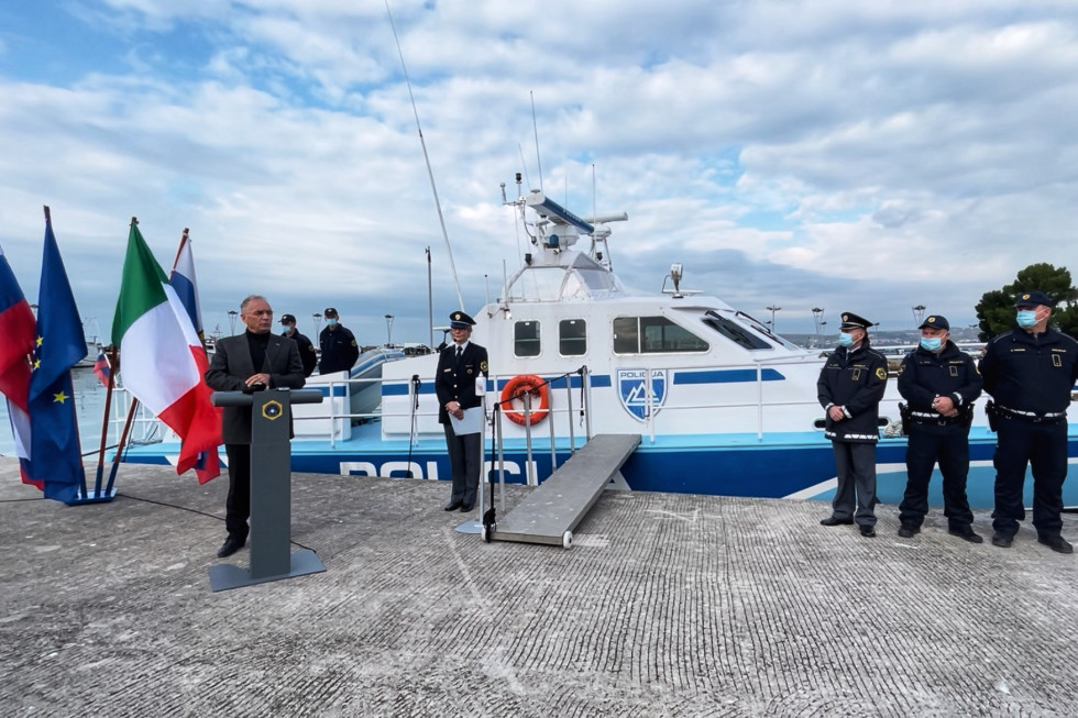 Nagovor ministra Aleša Hojsa pred zadnjo plovbo. Zadaj čoln.