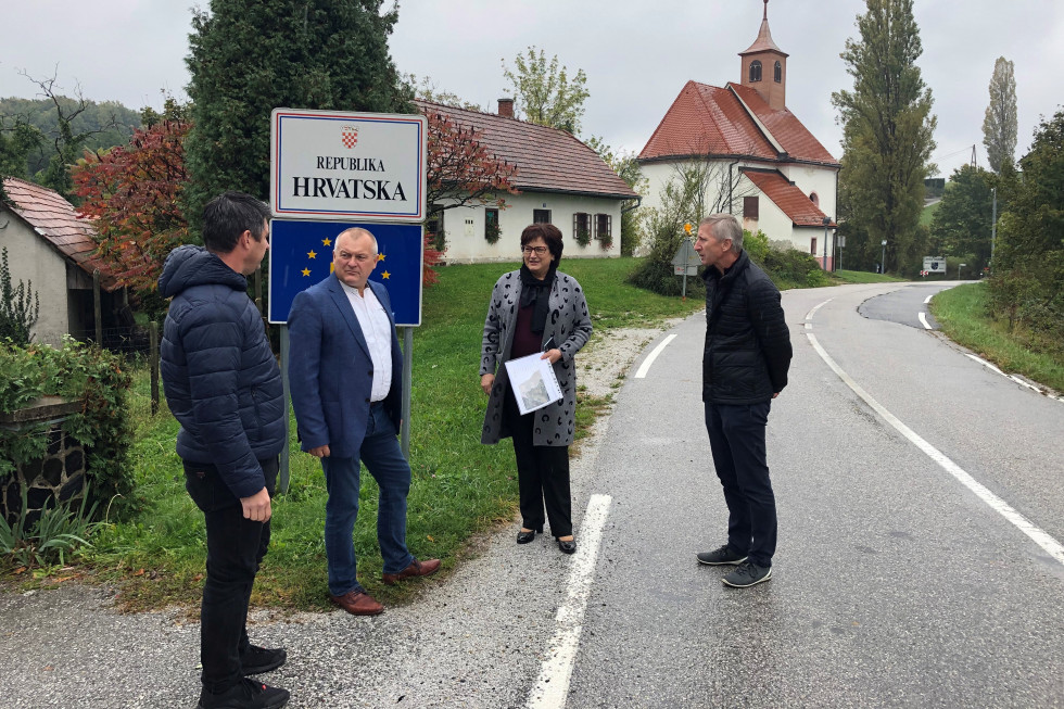 Državni sekretar Franc Kangler z županjo Občine Cirkulane Antonijo Žumbar. Stojita ob robu ceste. Na tabli je napis Republika Hrvatska, zadaj cerkev.