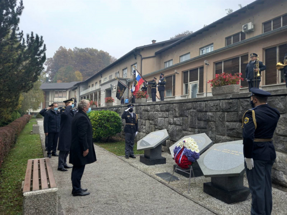  Minister za notranje zadeve Aleš Hojs in generalni direktor policije dr. Anton Olaj sta se poklonila v Parku spomina v Tacnu. Stojita pred tremi obeležji, na enem venec rož.