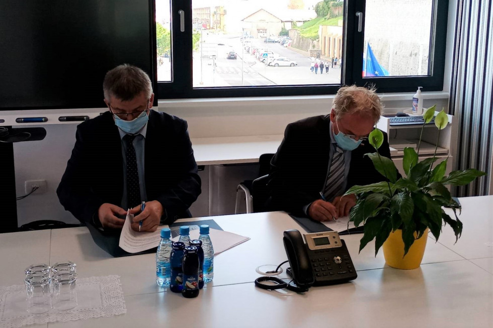 Pogodbo za novo Postajo pomorske policije Koper sta podpisala minister Aleš Hojs in direktor Marine Koper Štefan Činč. Sedita za mizo in podpisujeta, zadaj okno s pogledom na cesto