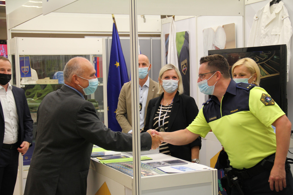 Državni sekretar Božo Predalič se rokuje s policistom