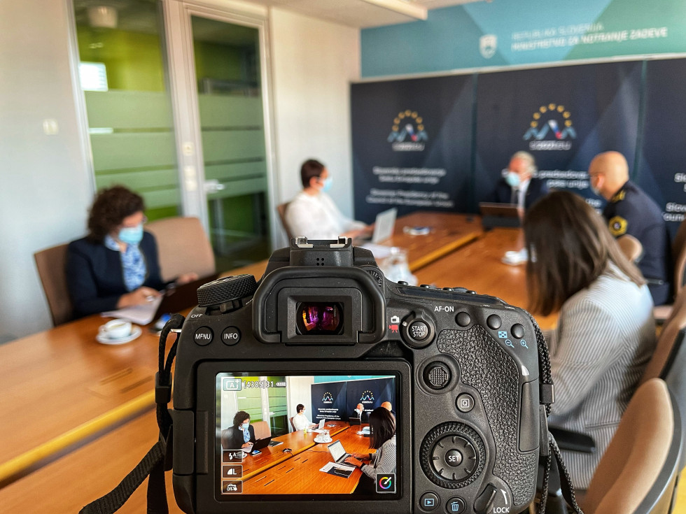 Participants at a table in the meeting room through the camera lens