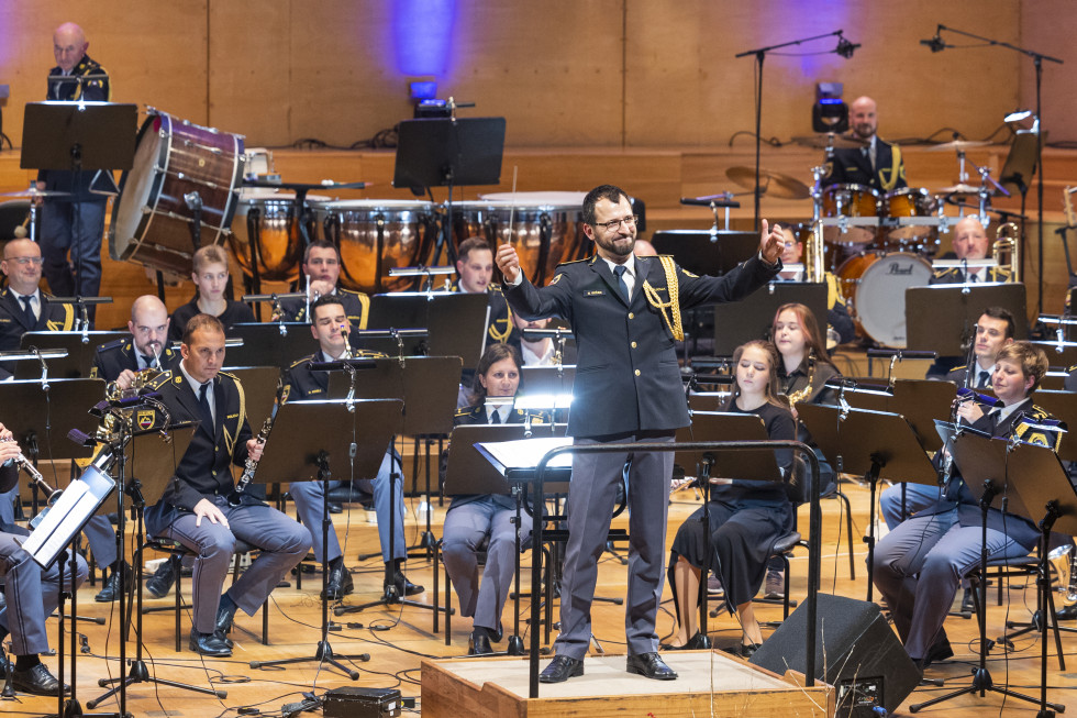 Policijski orkester in dirigent Nejc Bečan v Cankarjevem domu. Dirigent ima v zahvalo dvignjene roke.