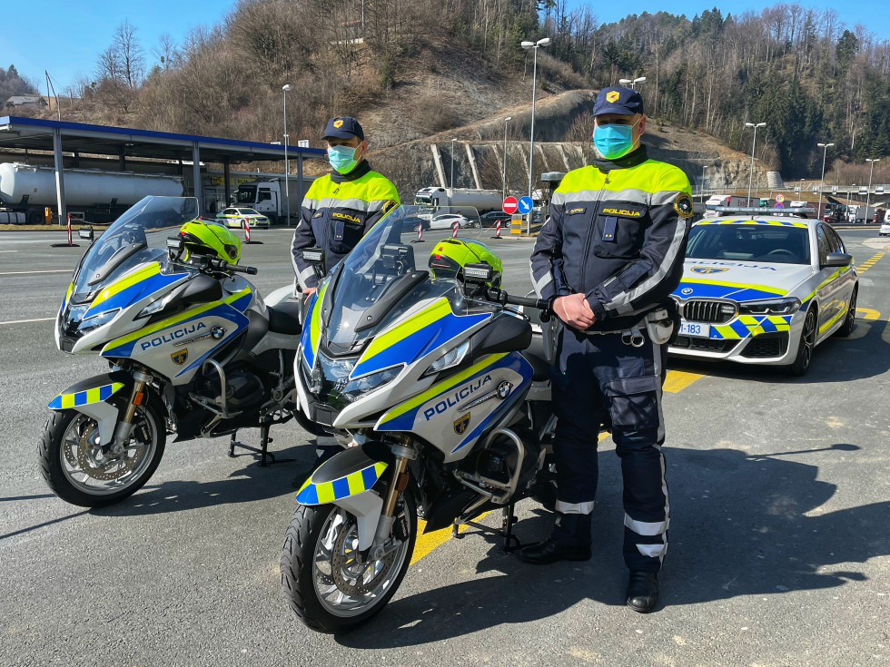 Policista motorista, stojita ob policijskih motornih kolesih
