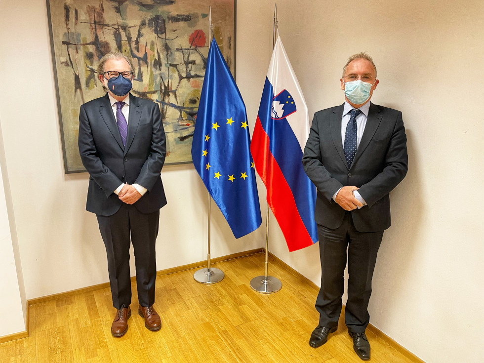 Španski veleposlanik Juan Aristegui Laborde in minister Aleš Hojs stojita pred evropsko in slovensko zastavo
