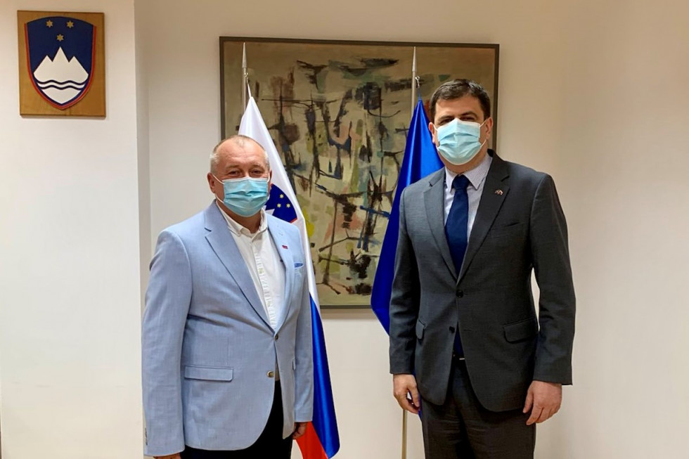 Državni sekretar Franc Kangler in veleposlanik Republike Kosovo Valdet Sadiku. Stojita pred zastavami, in umetniško sliko.