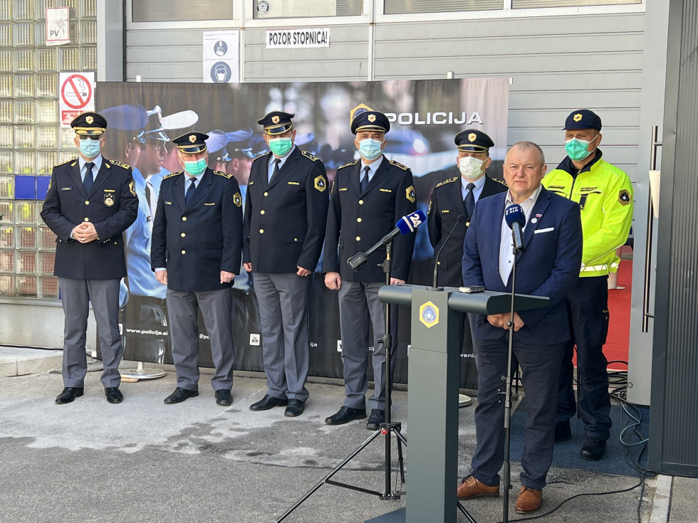 Nagovor državnega sekretarja Franca Kanglerja. Stoji za govornico, na njegovi desni policisti.