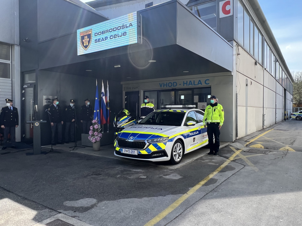 Odprtje Specializirane enote avtocestne policije Celje na Celjskem sejmu. Policijsko vozilo, ob njem policist na drugi strani delegacija ministrstva