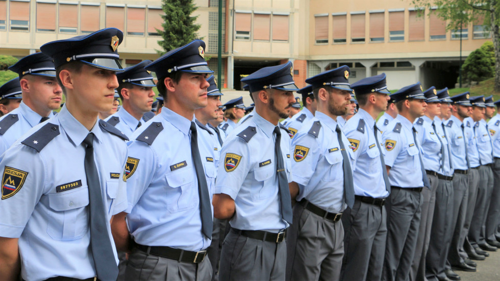 Policisti stojijo drug ob drugem v vrstah; oblečeni so v policijske uniforme