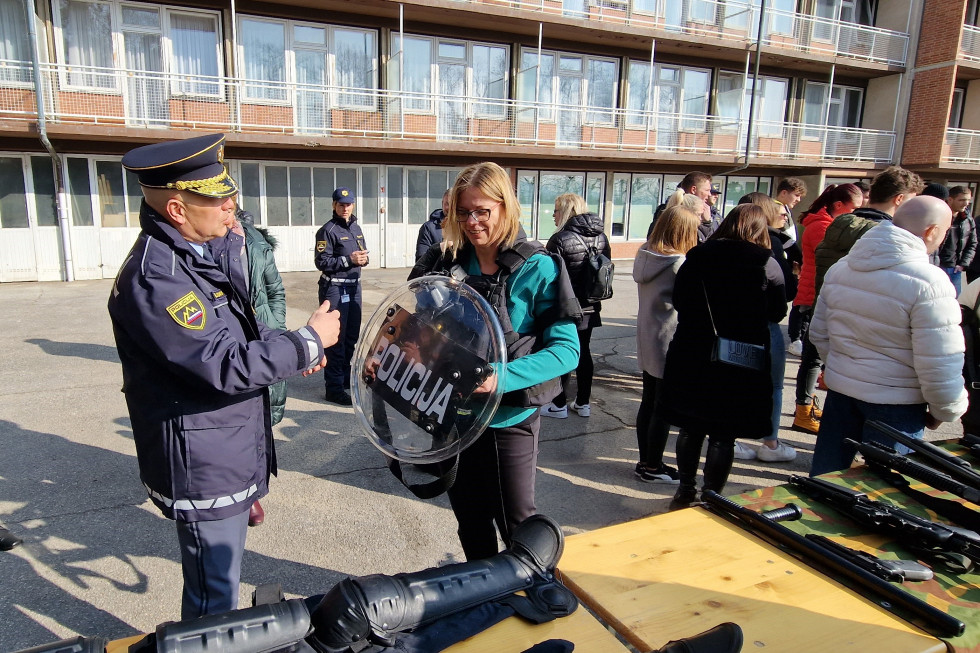 Ministrica Sanja Ajanović Hovnik si z vršilcem dolžnosti generalnega direktorja policije mag. Boštjanom Lindavom ogleduje opremo posebne policijske enote. V rokah drži ščit z napisom policija.