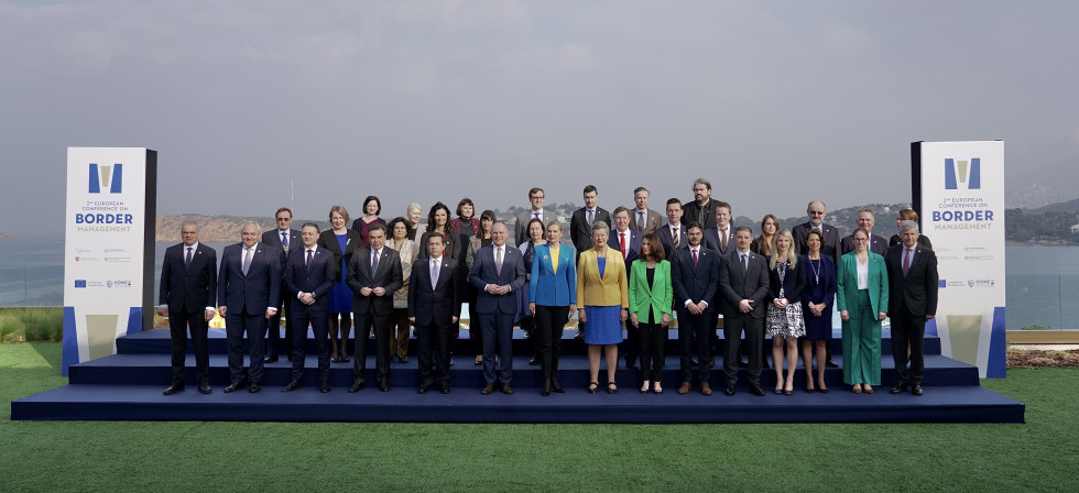 Udeleženci druge Evropske konference o upravljanju meja v Atenah. Okrog 30 ljudi stoji  na modri podlagi, zadaj nebo in morje.