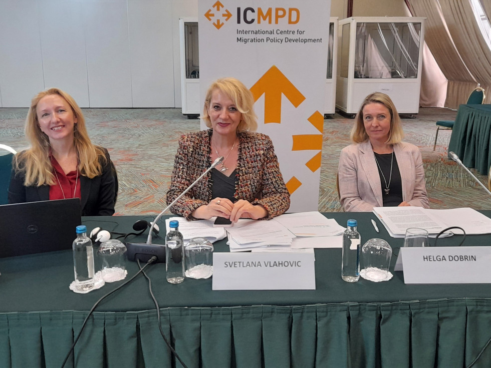 Državna sekretarka in nacionalna koordinatorica za boj proti trgovini z ljudmi Helga Dobrin sedi za mizo in posluša, ob njej sedita še dve gospe