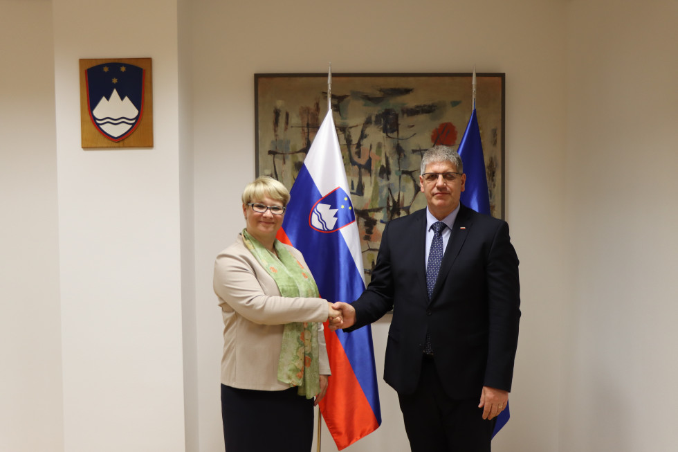 Rokovanje ministra Boštjana Poklukarja z vodjo Predstavništva Evropske komisije v Sloveniji Jernejo Jug Jerše, za njima slovenska in evropska zastava