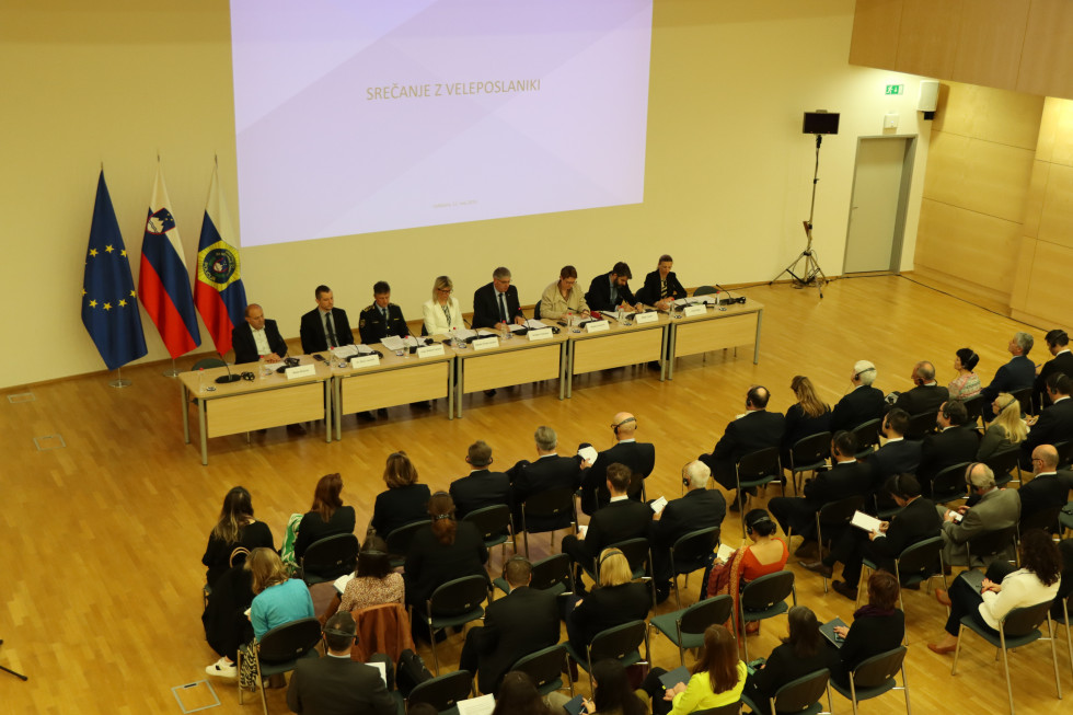 Participants in the hall. In front, a long table, behind which the leadership of the ministry sits, then the ambassadors on chairs in several rows.