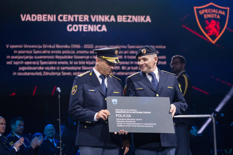 Vršilec dolžnosti generalnega direktorja policije in poveljnik Specialne enote držita tablo z napisom Vadbeni center Vinka Beznika Gotenica.
