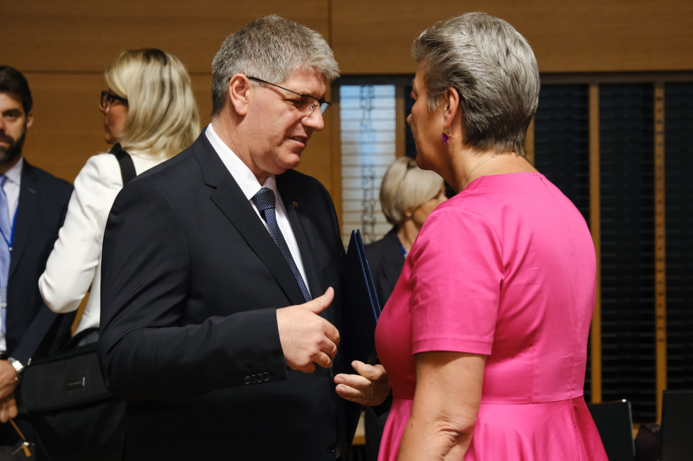 Minister Boštjan Poklukar is standing opposite European Commissioner Ylva Johansson, with whom they are talking.