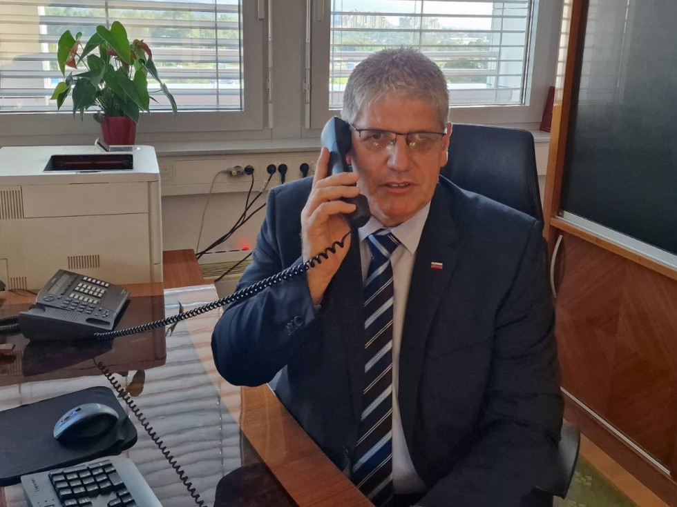 Telefonski pogovor ministra Boštjana Poklukarja, ki sedi za mizo in v roki drži telefonsko slušalko, z ministrom za varnost Bosne in Hercegovine Nenadom Nešićem