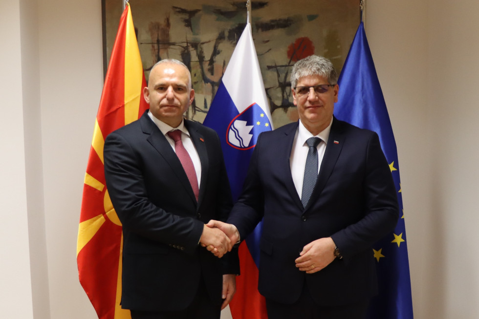 Minister Boštjan Poklukar se rokuje z direktorjem Uprave za javno varnost Ministrstva za notranje zadeve Severne Makedonije Sašem Tasevskim pred zastavami